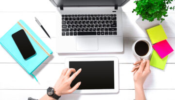 Hand use white tablet on desk table top view
